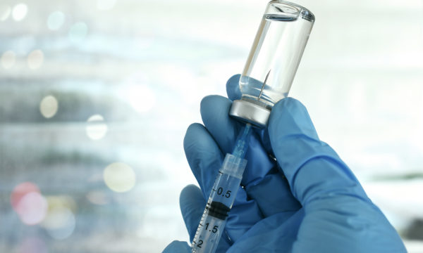 placing a syring in a bottle to get the medicine out