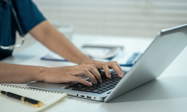 nurse typing on a laptop